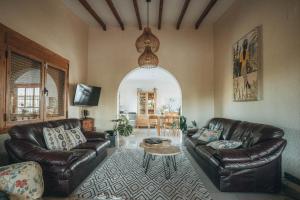 una sala de estar con 2 sofás de cuero y una mesa. en VILLAMÓNICA, en Torrellano