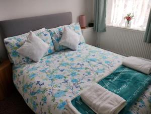 a bedroom with a bed with a blanket and pillows at Cwtch Cottage in Rhondda