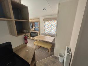 a small room with a wooden table and a chair at Butlins Skegness Caravan in Lincolnshire
