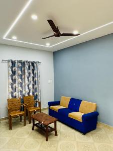 - un salon avec un canapé bleu et des chaises dans l'établissement The Saltwater Homestay, à Udupi