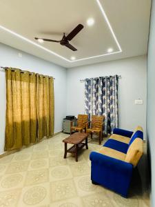 - un salon avec un canapé bleu et un ventilateur de plafond dans l'établissement The Saltwater Homestay, à Udupi