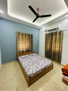 - une chambre avec un lit et un ventilateur de plafond dans l'établissement The Saltwater Homestay, à Udupi
