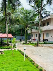 un bâtiment avec des palmiers et une allée dans l'établissement The Saltwater Homestay, à Udupi