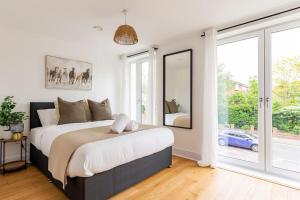 a bedroom with a large bed and a large window at Epsom Modern Luxury 1 Bed Apartment with Extra Sofa Bed - East Street in Epsom
