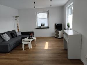 a living room with a couch and a tv at Schöne Ferienwohnung Nähe Biggesee in Berlinghausen