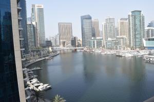 a view of a river with boats in a city at 1BR apartment, Stunning Dubai Marina view, 5 min walk to JBR beach, 30 sec walk to tram and bus stations in Dubai