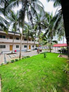 un parc avec des palmiers en face d'un bâtiment dans l'établissement The Saltwater Homestay, à Udupi