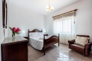 a bedroom with a bed and a chair at Alagoa Apartment in Altura