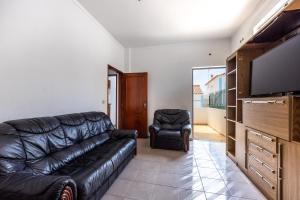 a living room with a leather couch and a chair at Alagoa Apartment in Altura