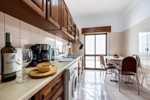a kitchen with a bottle of wine and a table at Alagoa Apartment in Altura