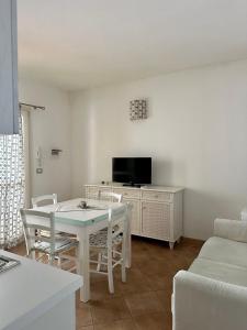 a living room with a table and a tv at Hotel Canne al Vento in Santa Teresa Gallura