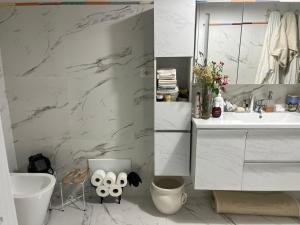 een badkamer met witte marmeren muren en een wastafel bij Nuoro Suite in Nuoro