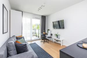 a living room with a gray couch and a table at SuperApart Bokserska 71a MiniStudio - near Chopin Airport in Warsaw