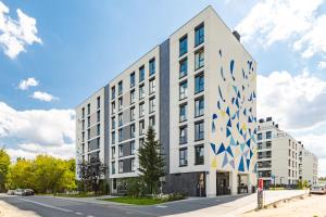 SuperApart Bokserska 71a MiniStudio في وارسو: مبنى ابيض كبير عليه تصاميم زرقاء وبيضاء