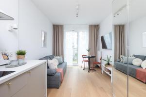 a kitchen and living room with a blue couch at SuperApart Bokserska 71a MiniStudio - near Chopin Airport in Warsaw +19 photos