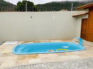 una piscina azul con una fuente de agua en un patio en Feitosa casa de madeira Meruoca, en Meruoca