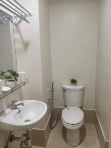 a white bathroom with a toilet and a sink at Studio with Balcony at The Loop Tower in Cagayan de Oro