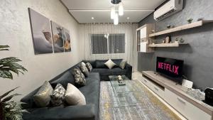 a living room with a couch and a tv at Haut Standing Appartement - Centre Ville Oujda in Oujda