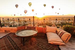 a room with a couch and a table and hot air balloons at Simera in Cappadocia - Special Class - Best View Rooftop in Uçhisar