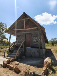 NarokにあるMasai Mara Explore Campの木製のドアと階段のある小さな石造りの家