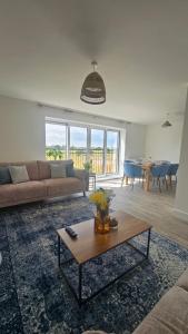 uma sala de estar com um sofá e uma mesa em The Oasis, SAV - Romney Sands Beach House em Littlestone-on-Sea