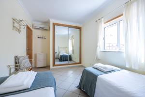 Un dormitorio con dos camas y una gran ventana. en Altura Beach, en Altura