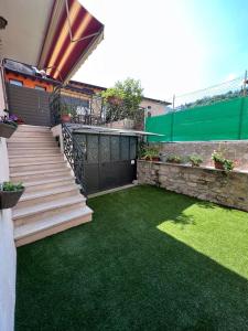 a backyard with a green yard with stairs and grass at Casa Caterina 2 storey house, with a mountain view in Toscolano Maderno