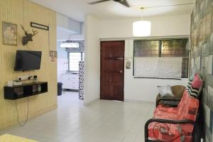 a living room with a couch and a tv at Comfy Home Near to Penang Hill in Ayer Itam