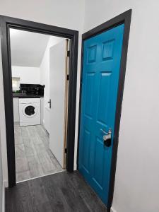 a blue door leading to a laundry room at Tudors eSuites Cosy Two Bedroom Apartment with 6 Beds in Birmingham