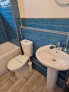 a bathroom with a toilet and a sink at Tudors eSuites Cosy Two Bedroom Apartment with 6 Beds in Birmingham