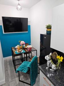 sala de estar con mesa y pared azul en Tudors eSuites Cosy Two Bedroom Apartment with 6 Beds en Birmingham