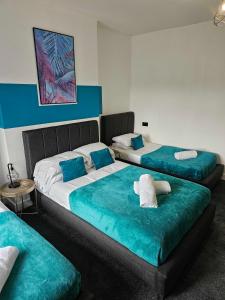 A bed or beds in a room at Tudors eSuites Cosy Two Bedroom Apartment with 6 Beds