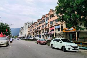 uma rua com carros estacionados na berma da estrada em Comfy Home Near to Penang Hill em Ayer Itam