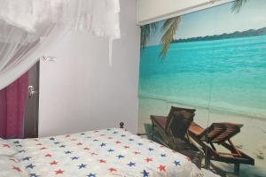 um quarto com uma cama e duas cadeiras ao lado de um quadro em Comfy Home Near to Penang Hill em Ayer Itam
