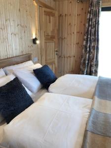 2 Betten in einem Zimmer mit weißer Bettwäsche und Kissen in der Unterkunft Neadín Beag in Tralee
