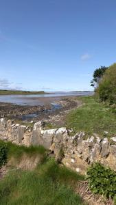 um campo com uma parede de rocha e um rio em Neadín Beag em Tralee