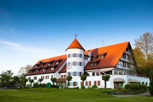 a large white building with an orange roof at Golfhotel Bodensee in Weißensberg