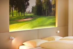 two beds in a room with a painting on the wall at Golfhotel Bodensee in Weißensberg