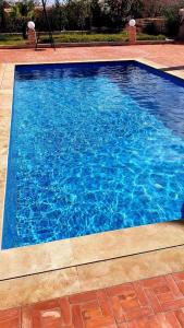 una grande piscina blu con acqua blu di Villa avec piscine privé a El Araïch