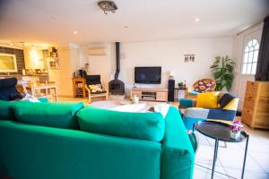 sala de estar con sofá verde y sillas en L'amigeste, en Pouzols-Minervois
