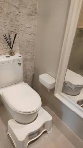 a bathroom with a white toilet and a mirror at Vinn condo in Amphoe Phra Khanong