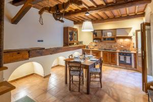 kuchnia z drewnianym stołem i krzesłami w obiekcie La Corte del Podestà w mieście Sarteano