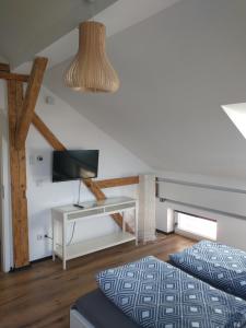 a bedroom with two beds and a desk with a television at Bad Aibling City Apartment - Pano in Bad Aibling