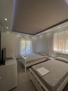 a bedroom with two beds and a tv in it at Mavalux apartments in Tivat