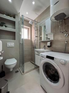 a bathroom with a washing machine and a toilet at Mavalux apartments in Tivat