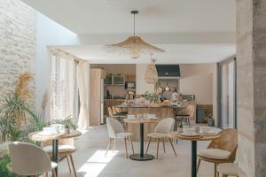 een keuken en een woonkamer met tafels en stoelen bij Le Mas de Fanfan in Le Cailar