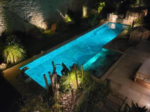 una vista aérea de una piscina por la noche en Le Mas de Fanfan, en Le Cailar