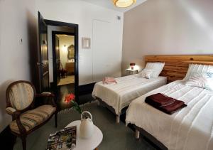 1 Schlafzimmer mit 2 Betten, einem Stuhl und einem Tisch in der Unterkunft Maison d'Hôtes " L'INSTANT D'AILLEURS" in Albi