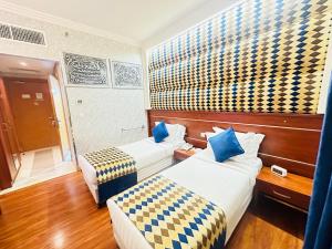 Pokój hotelowy z 2 łóżkami z biało-niebieskimi poduszkami w obiekcie Nusk Al Madinah w Medynie