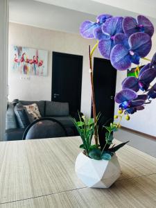 a vase with purple flowers sitting on a table at BOBLINE BAKURIANI SUITE in Bakuriani